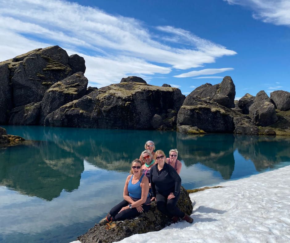 Women at turquoise lake with snow