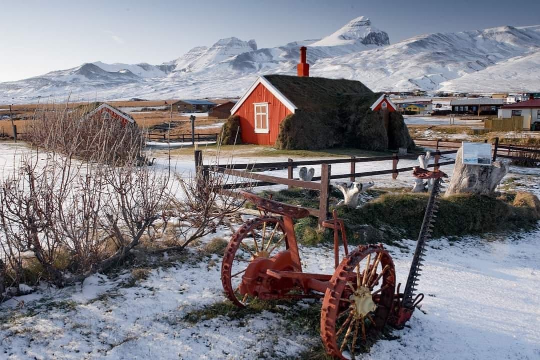Traditional Icelandic turf house with farm equipment